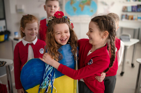 Happy children in school embracing with painted he 2026 03 10 01 59 07 utc