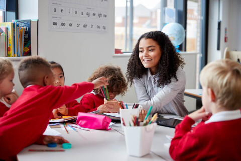 Smiling female infant school teacher sitting at a 2026 01 05 06 30 55 utc